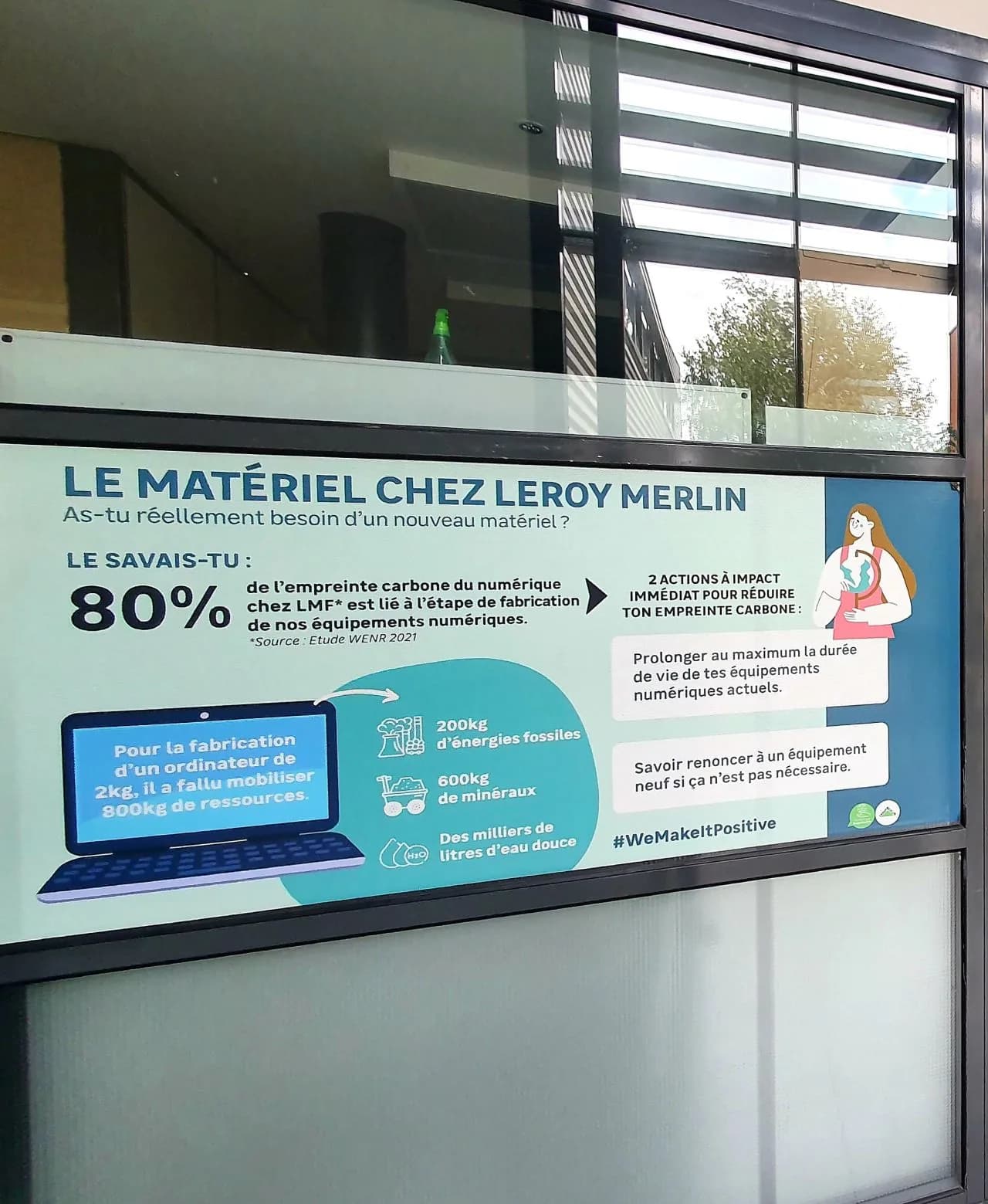 Poster "Equipment at Leroy Merlin" on a window, reminding people that 80% of digital's carbon footprint comes from manufacturing devices