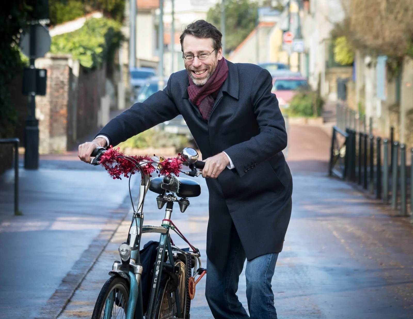 Stein van Oosteren in the street, pushing a bike decorated with garlands