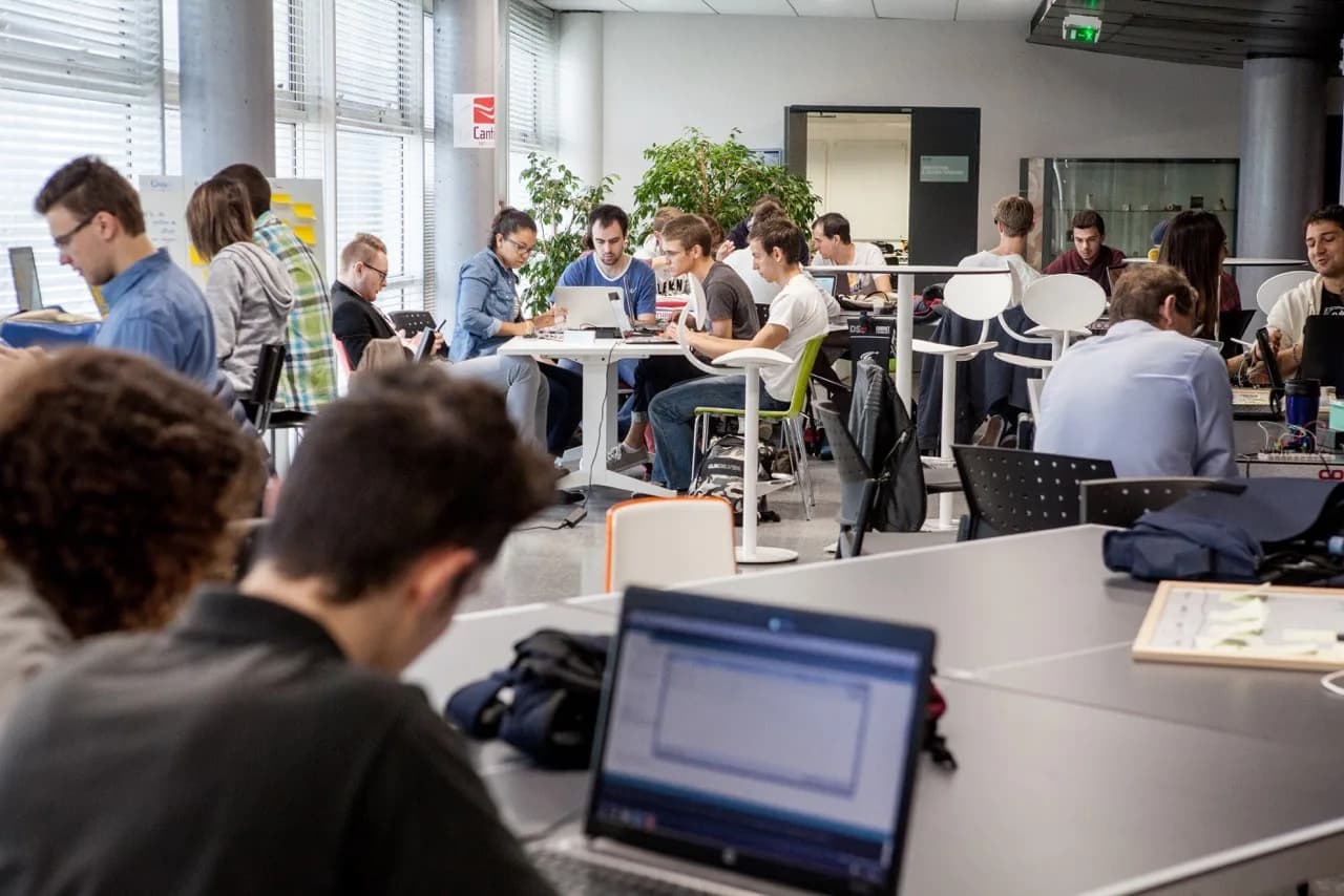 Students working on their computers in a shared workspace