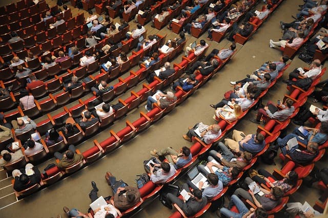 Audience seated in a large lecture hall during a talk
